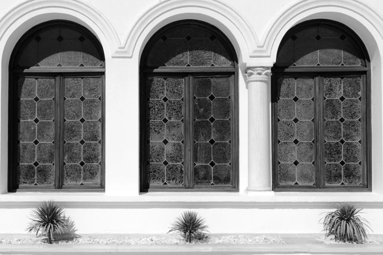 a black and white photo of three arched doors, inspired by Luis Paret y Alcazar, glass window, white architecture, bay window, stained”