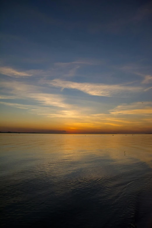 the sun is setting over a body of water, flickr, perfectly calm waters, today\'s featured photograph 4k, bay, humid evening