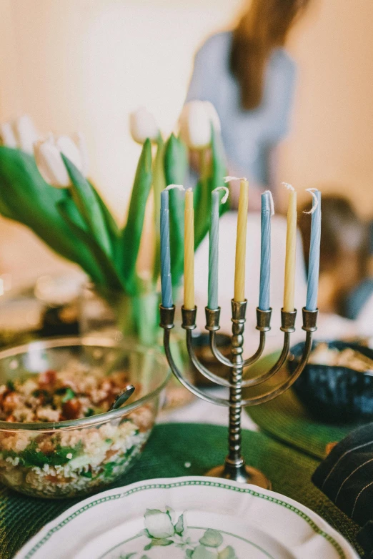 a close up of a plate with a menorah on it, pexels, lights with bloom, green and blue and warm theme, snacks, professionally color graded