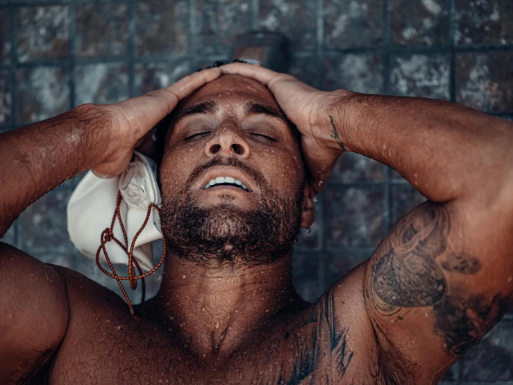 a shirtless man wearing headphones in front of a brick wall, by Cosmo Alexander, pexels contest winner, renaissance, covered in water drops, manly face, indigenous man, muscular men entwined together