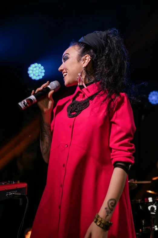 a woman in a red dress singing into a microphone, ashteroth, slide show, betty la fea, profile image