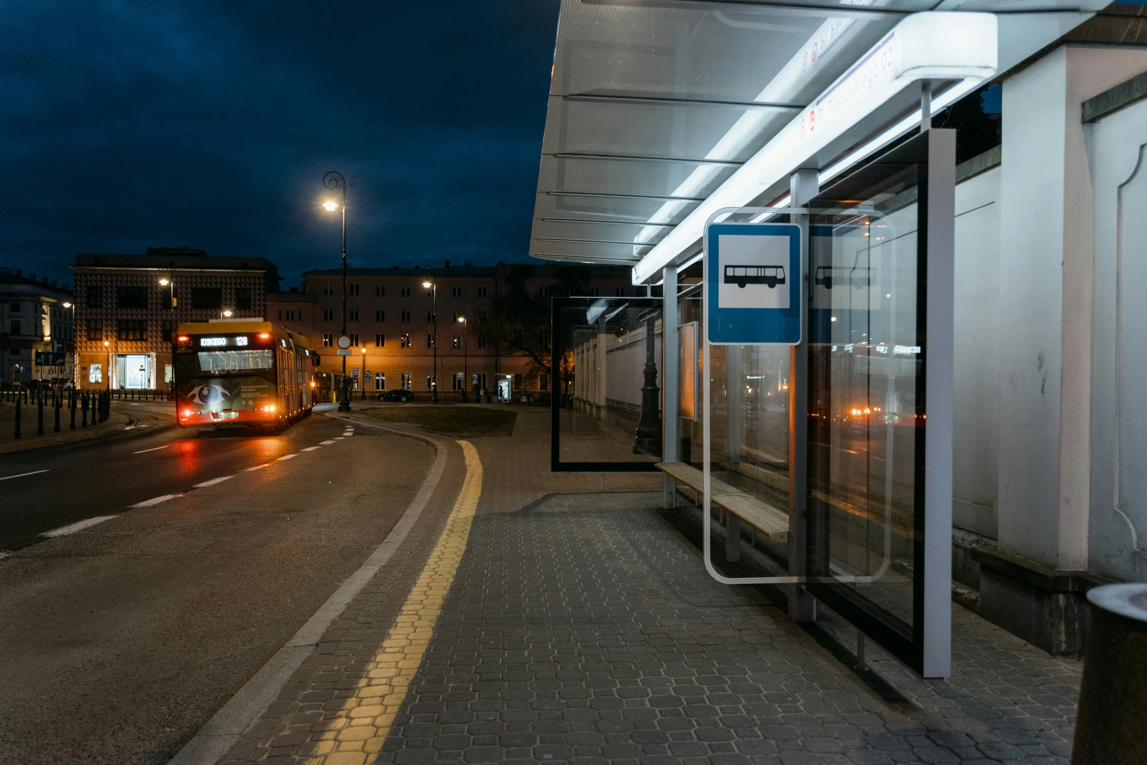 a bus stopped at a bus stop at night, a picture, by Giuseppe Avanzi, unsplash, square, espoo, underground facility, canopies