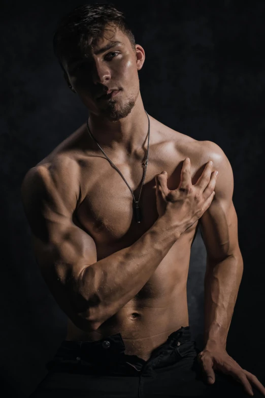 a shirtless man standing in front of a black background, an album cover, by Adam Marczyński, pexels contest winner, renaissance, showing off biceps, asian male, skinny caucasian man, beads cross onbare chest