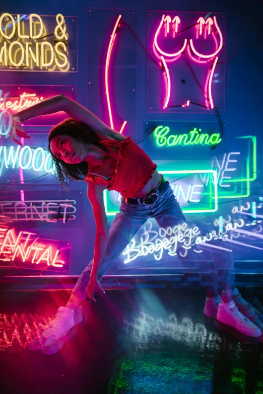 a woman standing in front of neon signs, inspired by David LaChapelle, trending on pexels, playful pose of a dancer, isabela moner, posing for a picture, neon basement