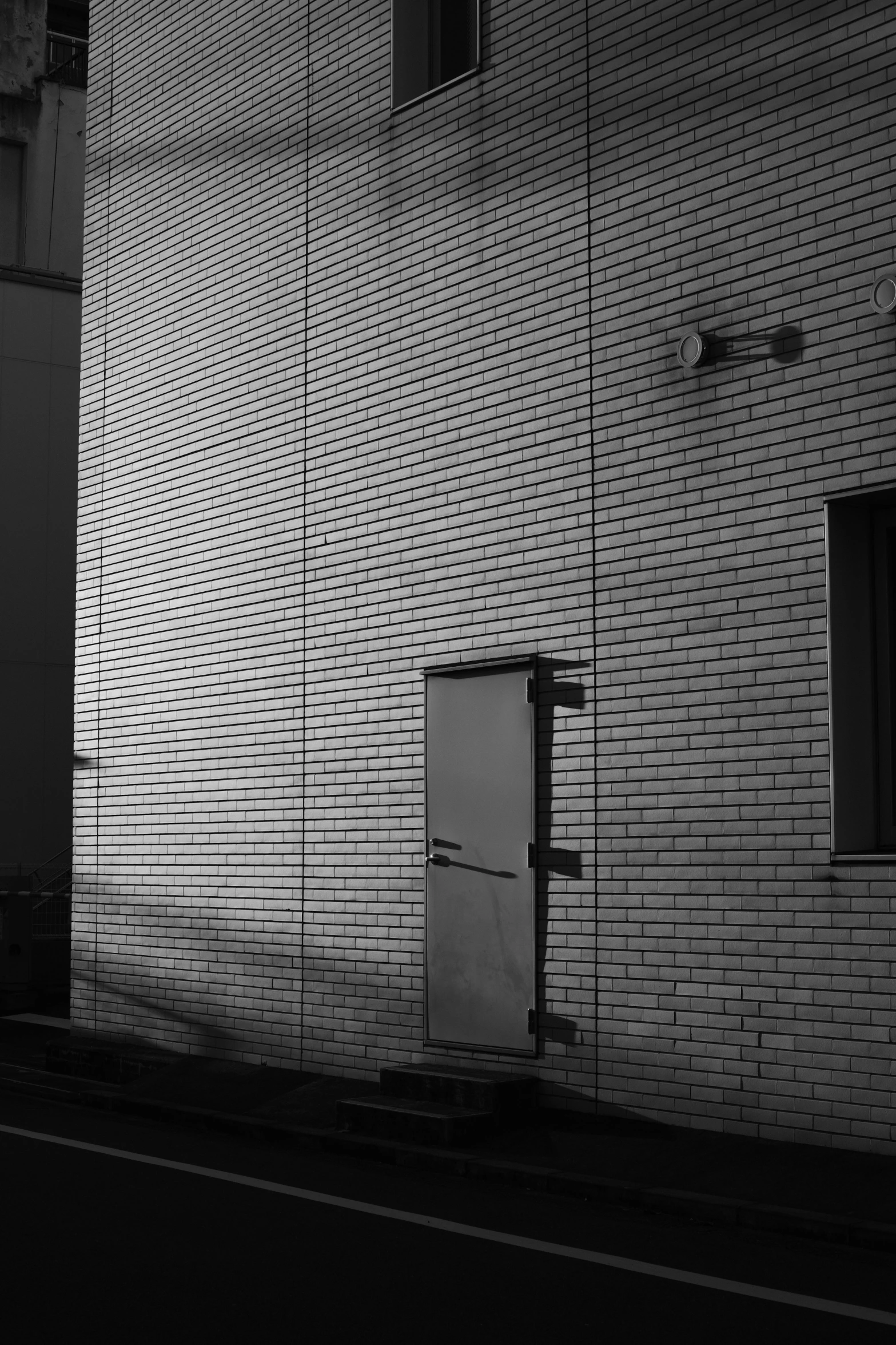 a black and white photo of a building, a black and white photo, unsplash, postminimalism, door to lab, evening sunlight, bricks, in tokio
