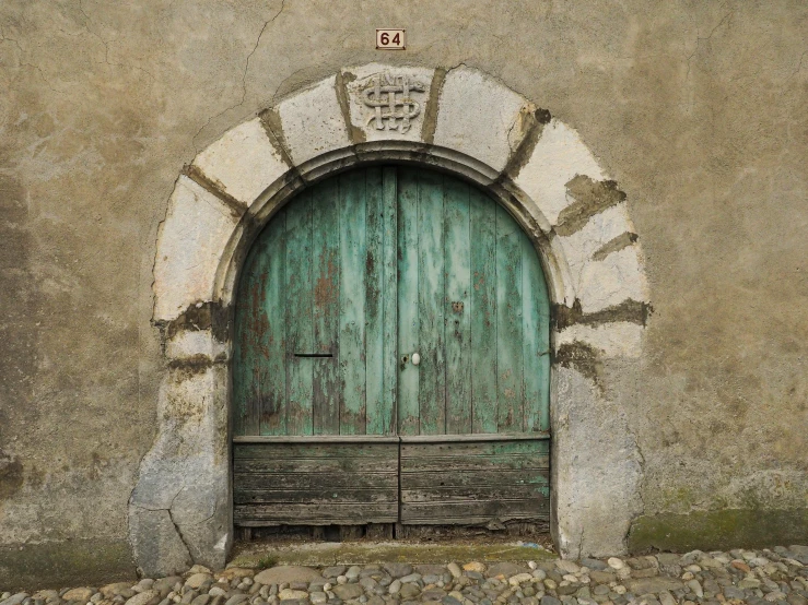 an old stone building with a green door, an album cover, pexels contest winner, renaissance, verdigris, eugene grasset, grey, rustic