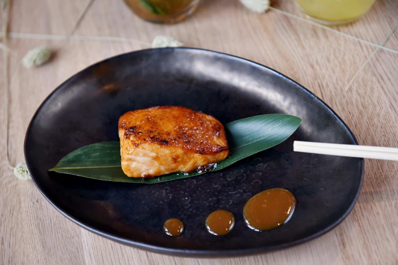 a close up of a plate of food on a table, a portrait, inspired by Kanō Shōsenin, unsplash, sōsaku hanga, maple syrup sea, square, smouldering charred timber, monaco