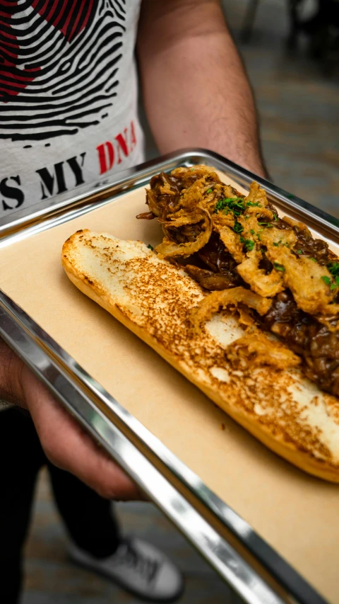 a man holding a tray with a sandwich on it, beef, tatterdemalion, shot with sony alpha 1 camera, no cropping