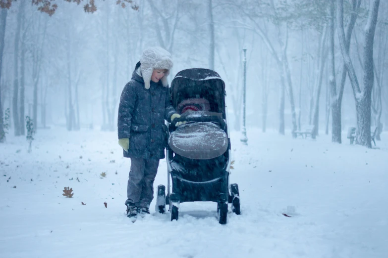 a woman pushing a stroller in the snow, inspired by Myles Birket Foster, pexels contest winner, realism, little boy, avatar image, snowstorm ::5, asleep