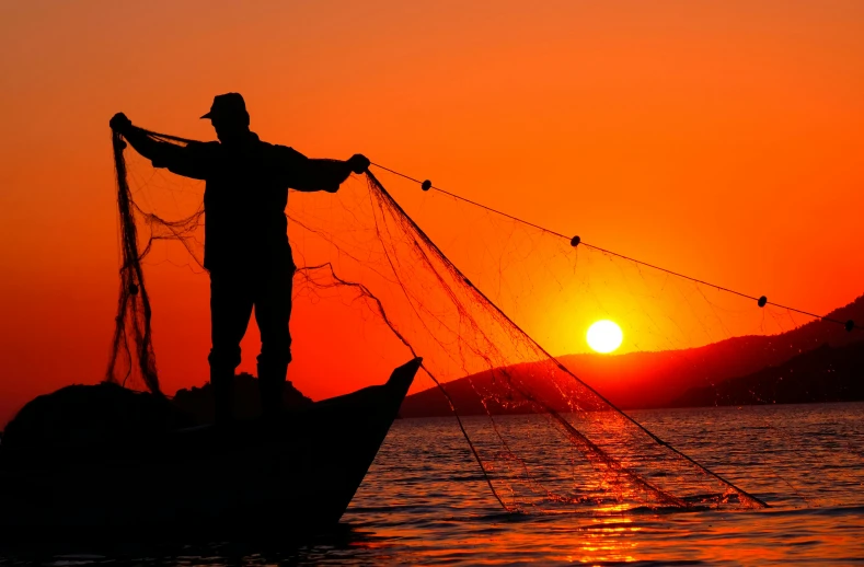 a man standing on top of a boat holding a fishing net, pexels contest winner, sunsetting color, profile pic, thumbnail