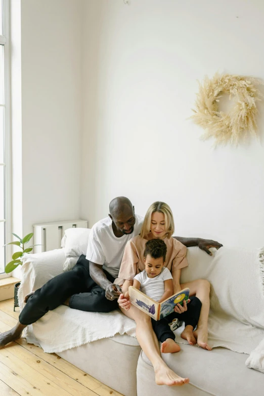 a couple of people that are sitting on a couch, pexels contest winner, with a kid, brown and white color scheme, reading, product introduction photo