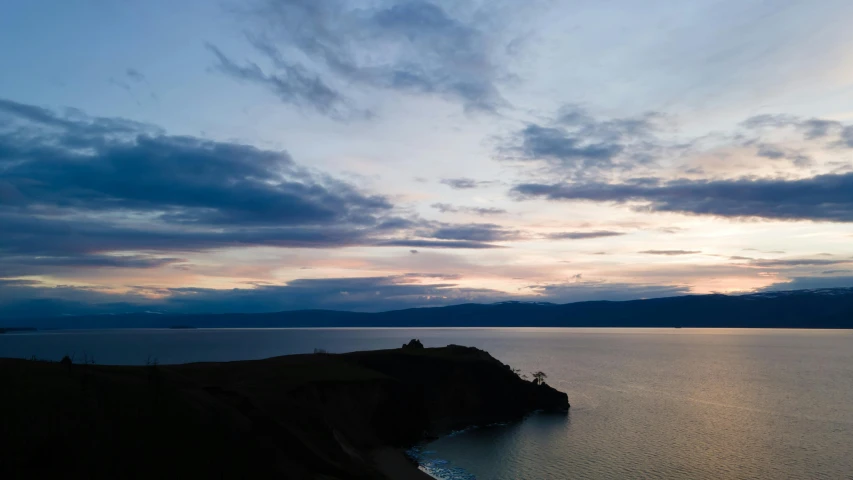 a large body of water under a cloudy sky, unsplash contest winner, romanticism, cliff side at dusk, bay area, te pae, slide show