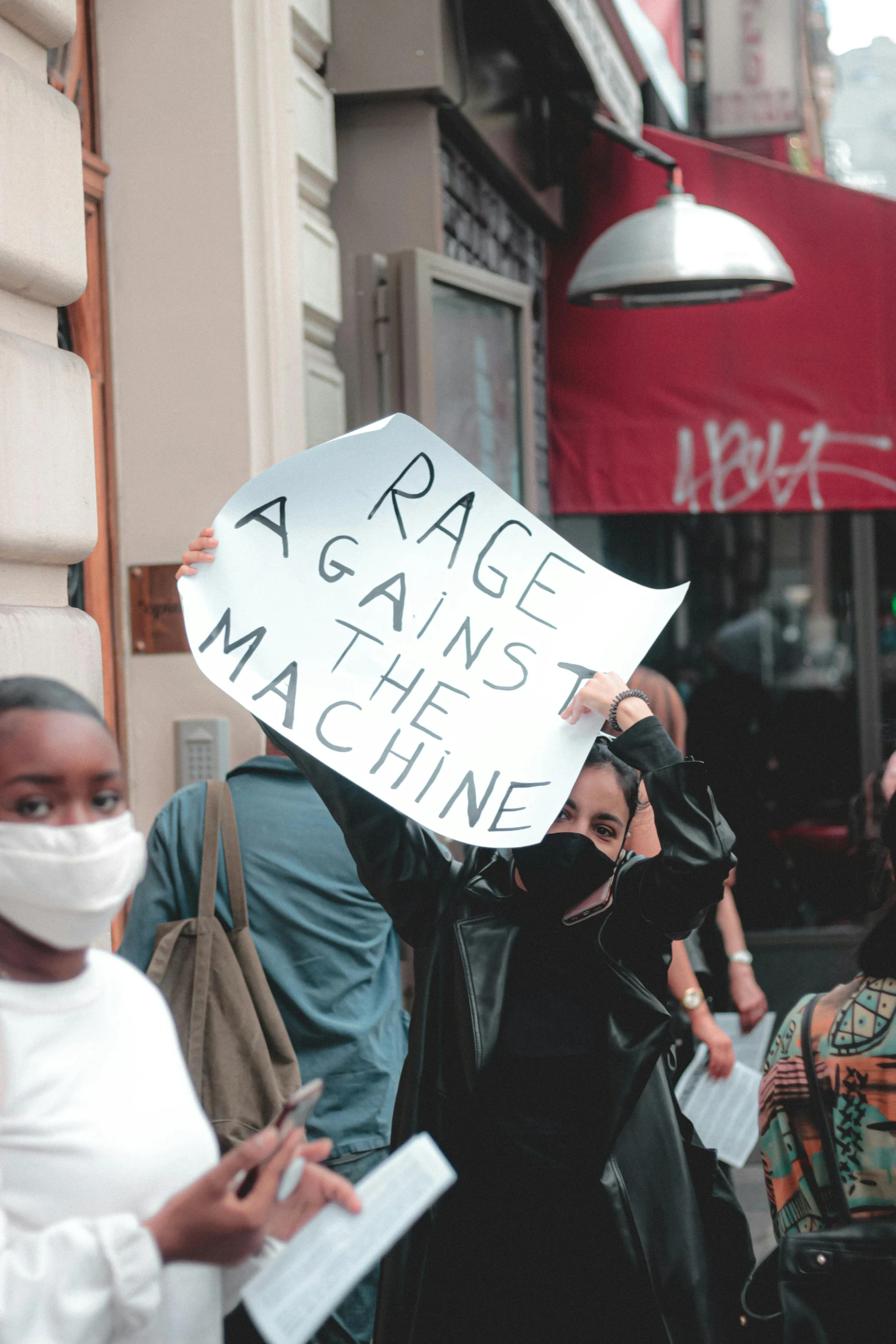 a group of people walking down a street holding signs, by Arabella Rankin, unsplash contest winner, renaissance, broke machines, rage, in front of a garage, machine parts embedded into face