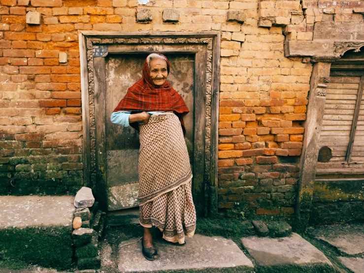 a woman that is standing in front of a door, inspired by Steve McCurry, pexels contest winner, nepal, grandma, clothed in ancient, ancient”