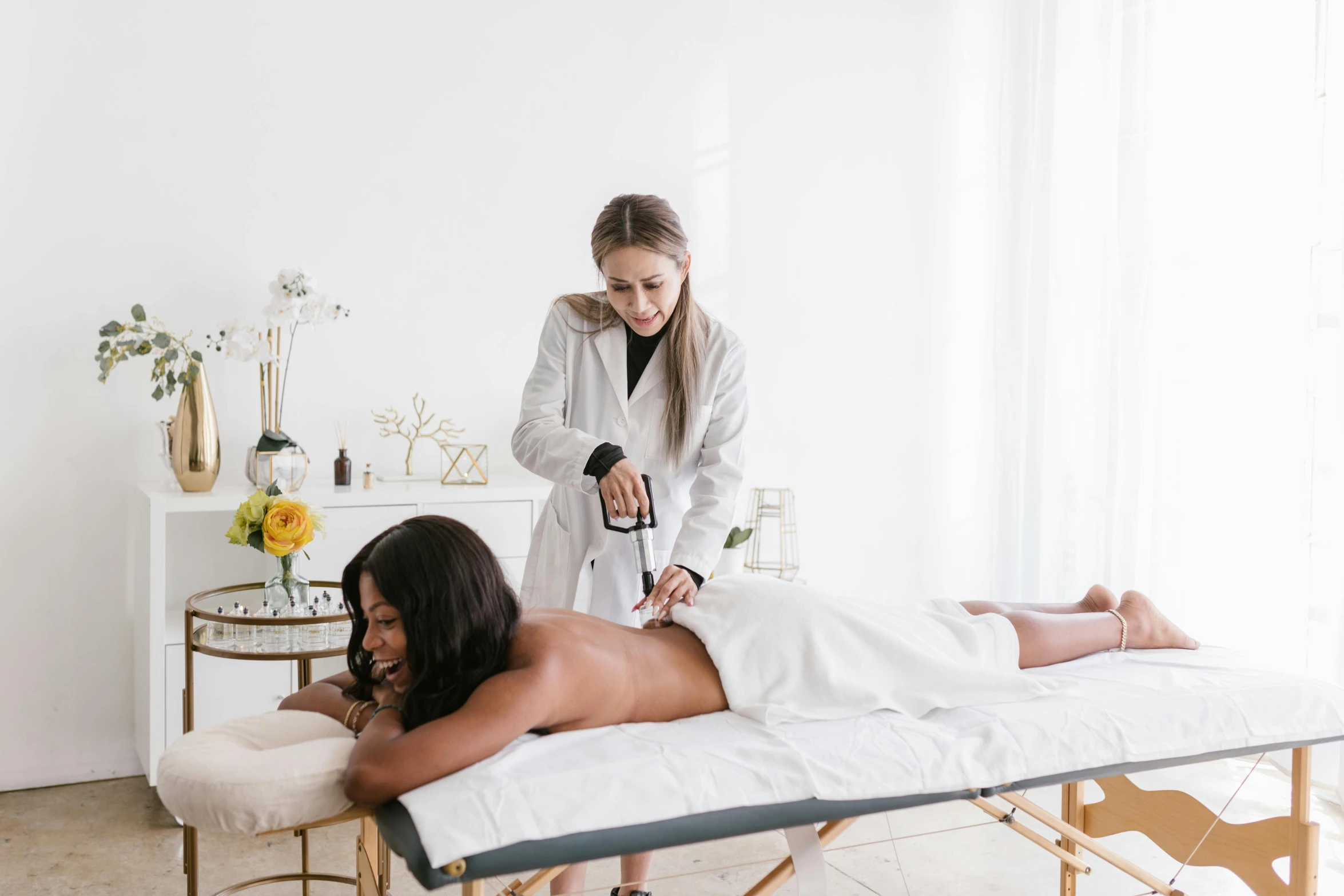 a woman getting a massage in a white room, camilla luddington, diverse, apothecary, with electric arc device