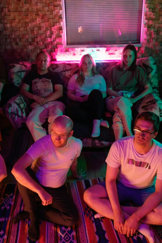 a group of people sitting in a room, inspired by Nan Goldin, maximalism, cinematic neon uplighting, midsommar - t, band promo photo, group of seven