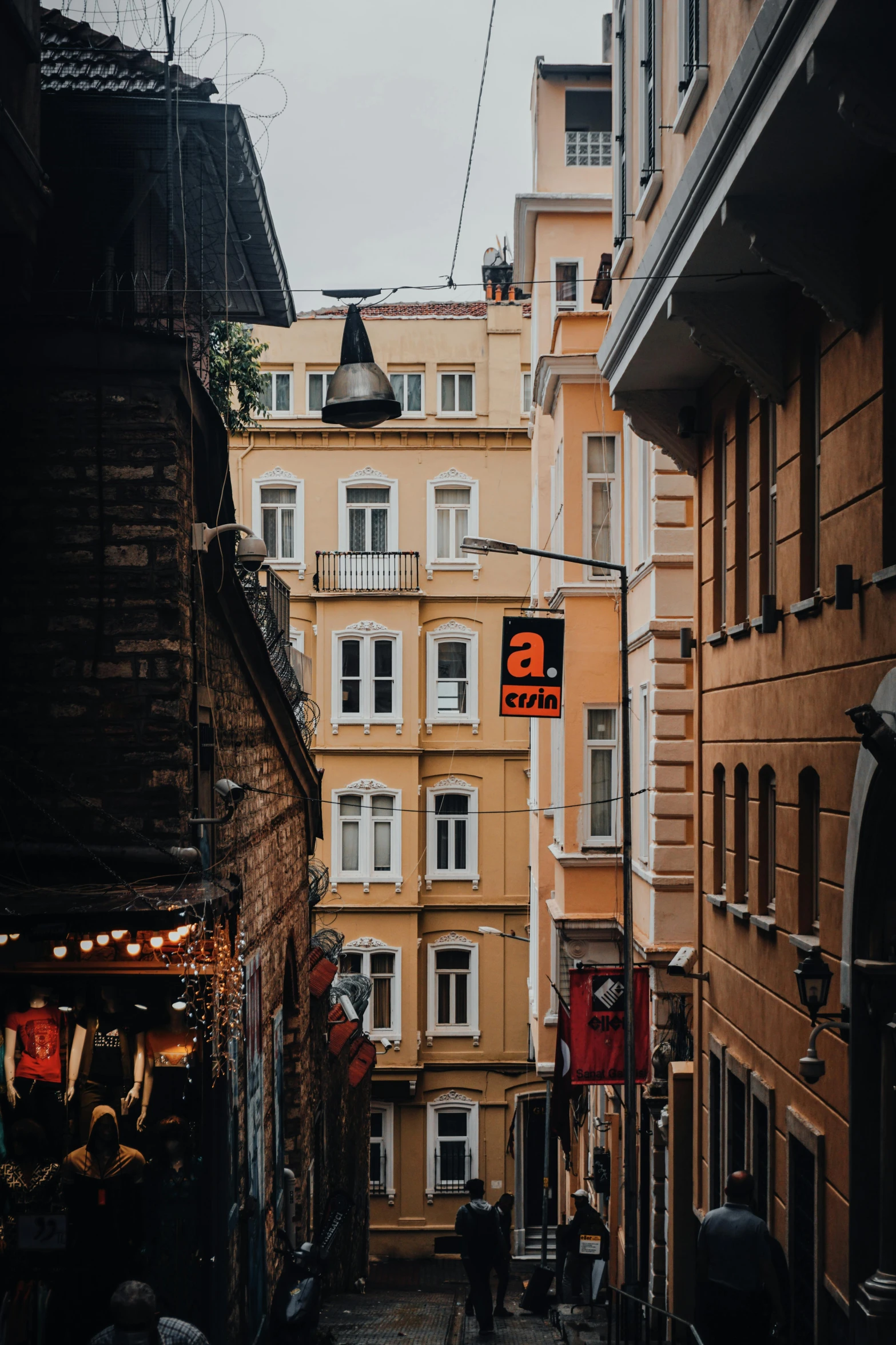 a couple of people walking down a street next to tall buildings, pexels contest winner, art nouveau, turkey, alleys, stores, viewed from a distance