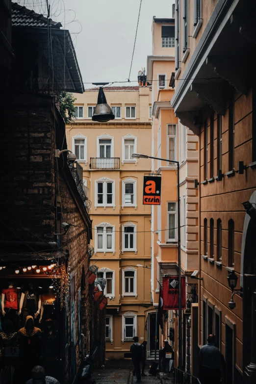 a couple of people walking down a street next to tall buildings, pexels contest winner, art nouveau, turkey, alleys, stores, viewed from a distance