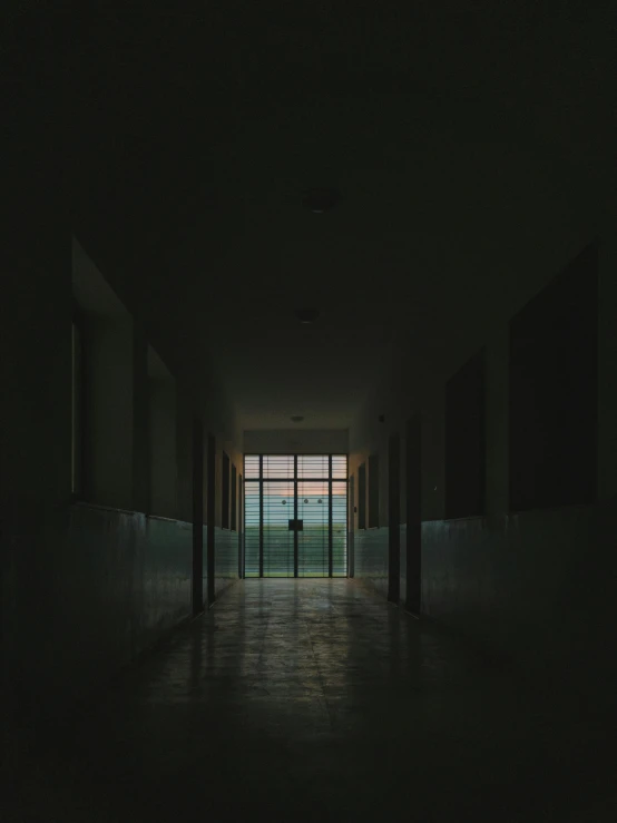 a person standing at the end of a long hallway, inspired by Elsa Bleda, unsplash contest winner, private school, ominous photo, door to lab, view from inside