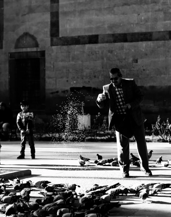 a black and white photo of a man surrounded by pigeons, a black and white photo, by Ahmed Yacoubi, action painting, families playing, sparkling in the sunlight, shooting ice, kids playing