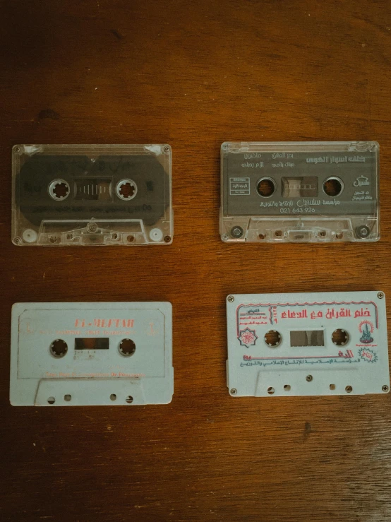 three cassettes sitting on top of a wooden table, inspired by Elsa Bleda, pexels, old experimentation cabinet, various artists, ignant, low quality photo