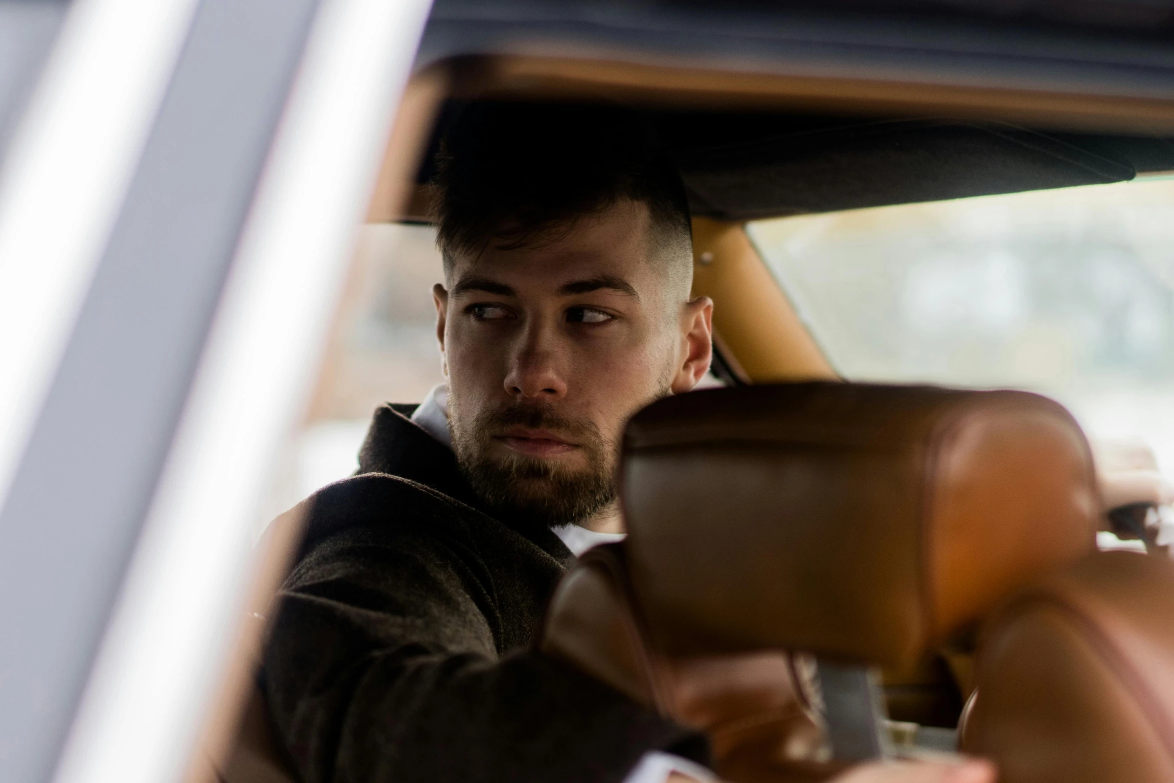 a man sitting in the driver's seat of a car, a portrait, by Daniel Seghers, pexels contest winner, square, post malone, serious business, brown