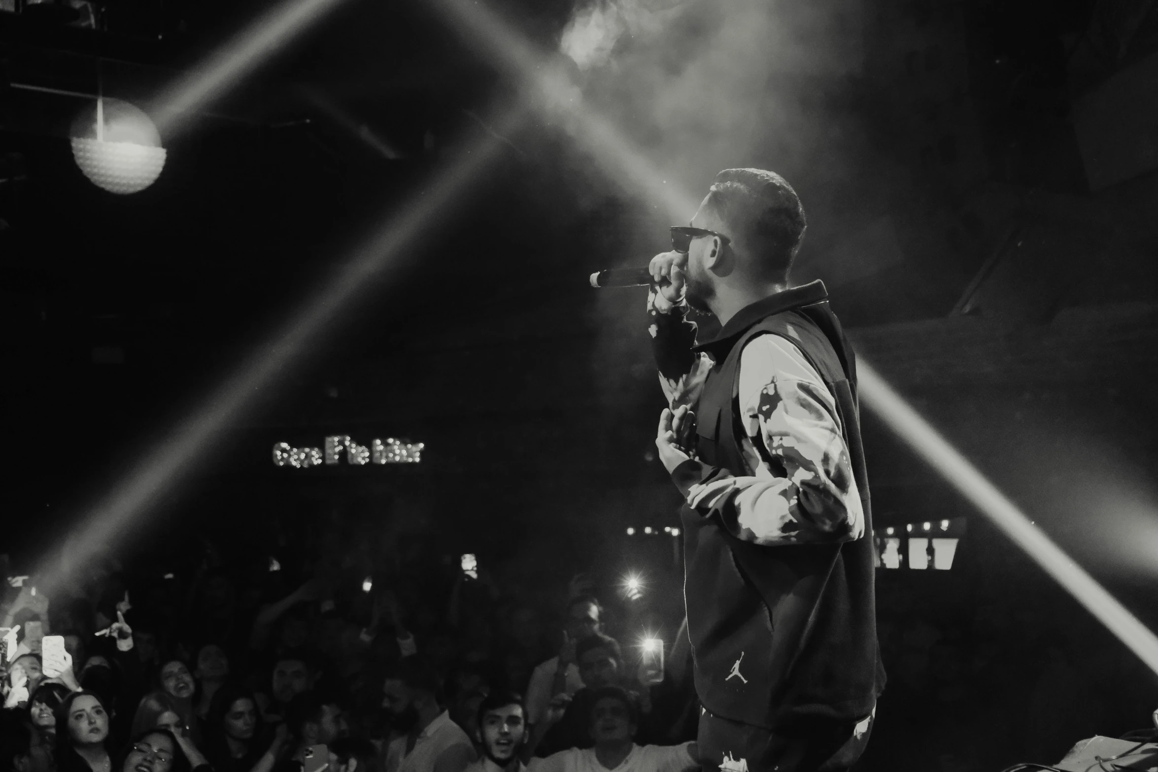 a man standing on top of a stage holding a microphone, a black and white photo, by Cafer Bater, pexels, les nabis, 2 rappers on stage at concert, background image, instagram picture, sk