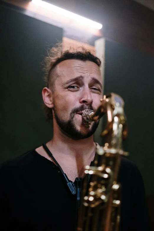 a man with a beard playing a saxophone, an album cover, inspired by František Jakub Prokyš, pexels contest winner, looking to the side off camera, australian, scruffy looking, paulie shore