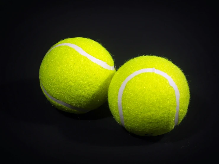 two tennis balls on a black background, by Joe Bowler, unsplash, replica model, 3/4 view from below, gaming, decoration