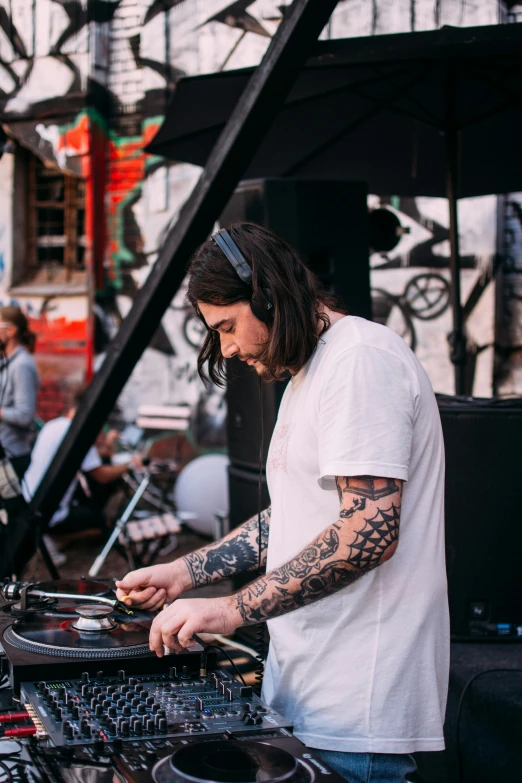 a man that is playing some kind of music, trending on unsplash, djing with dj turntables, tattooed man, dave grohl, aussie baristas