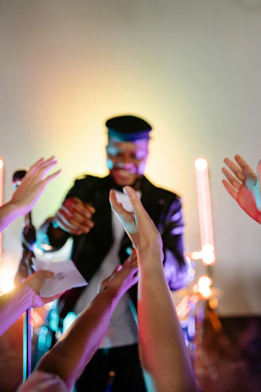 a group of people raising their hands in the air, an album cover, pexels, happening, scene from church, magician, vibrant glow, he is greeting you warmly