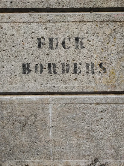 a sign that is on the side of a building, graffiti, ((rocks)), no borders, concrete poetry, 1 8 7 7
