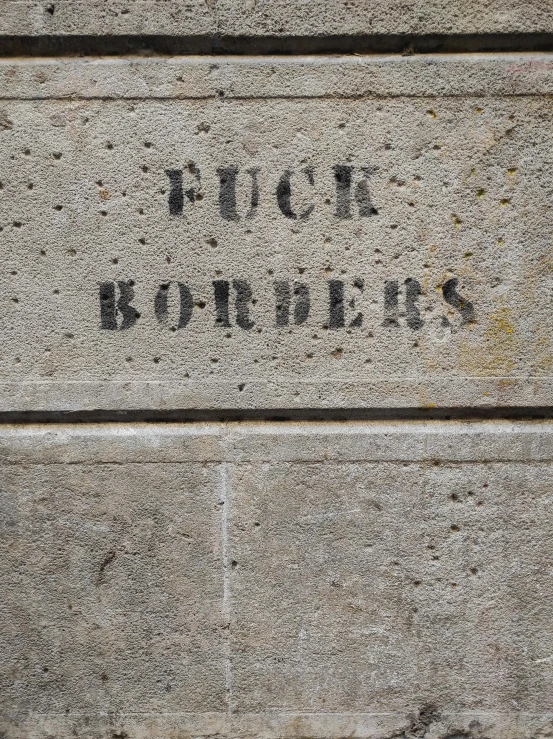 a sign that is on the side of a building, graffiti, ((rocks)), no borders, concrete poetry, 1 8 7 7