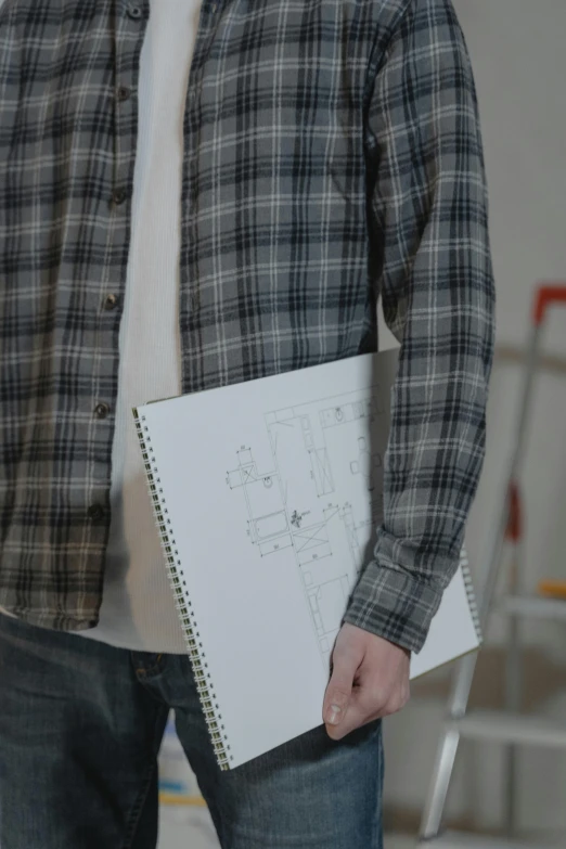 a man in a plaid shirt holding a notebook, a drawing, trending on reddit, commercial, complex design, low quality photo, cinematic image