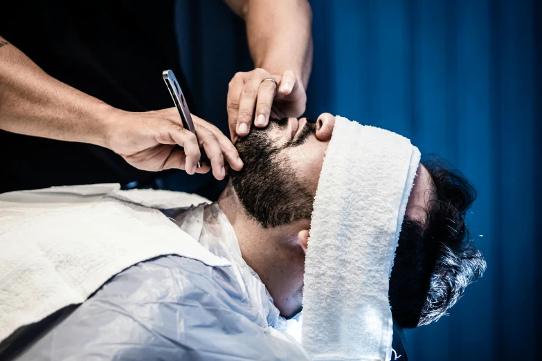 a man getting his hair cut by a barber, unsplash, thick black beard, square masculine jaw, thumbnail, full colour