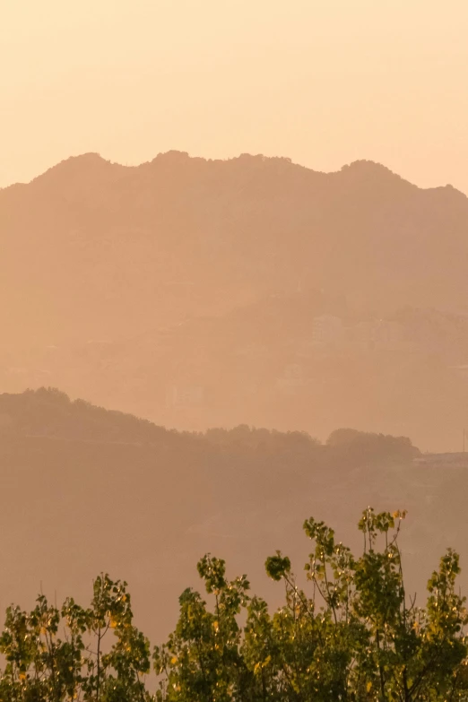 a large jetliner flying over a lush green hillside, inspired by Zhang Kechun, flickr, tonalism, sun rises between two mountains, alvaro siza, seen from a distance, golden hour in beijing