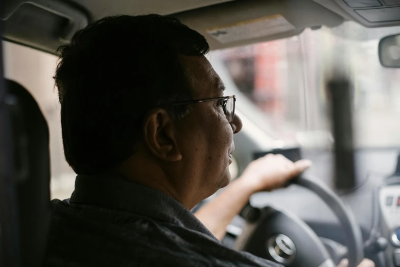 a man driving a car on a city street, pexels contest winner, shin hanga, avatar image, man with glasses, full frame image