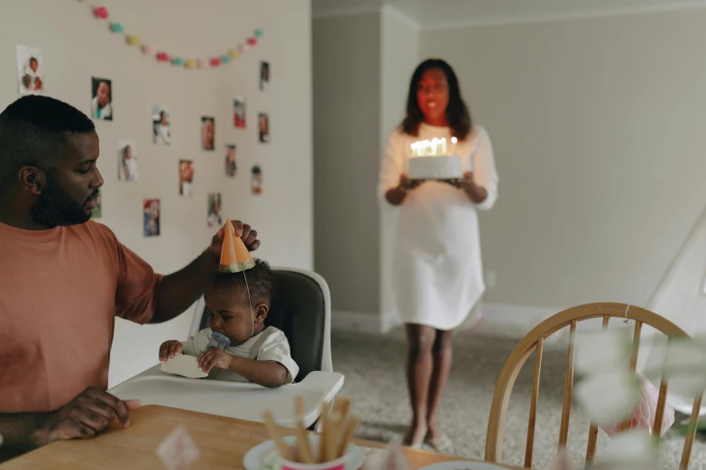 a man sitting at a table with a baby in a high chair, happy birthday candles, photo of a black woman, 15081959 21121991 01012000 4k, cleanest image
