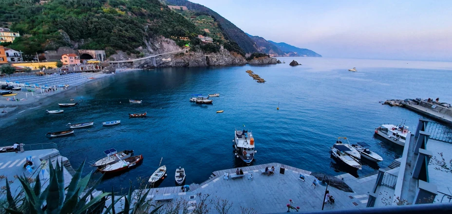 a group of boats sitting on top of a body of water, by Carlo Martini, pexels contest winner, cinq terre, 2 5 6 x 2 5 6 pixels, early evening, lush surroundings