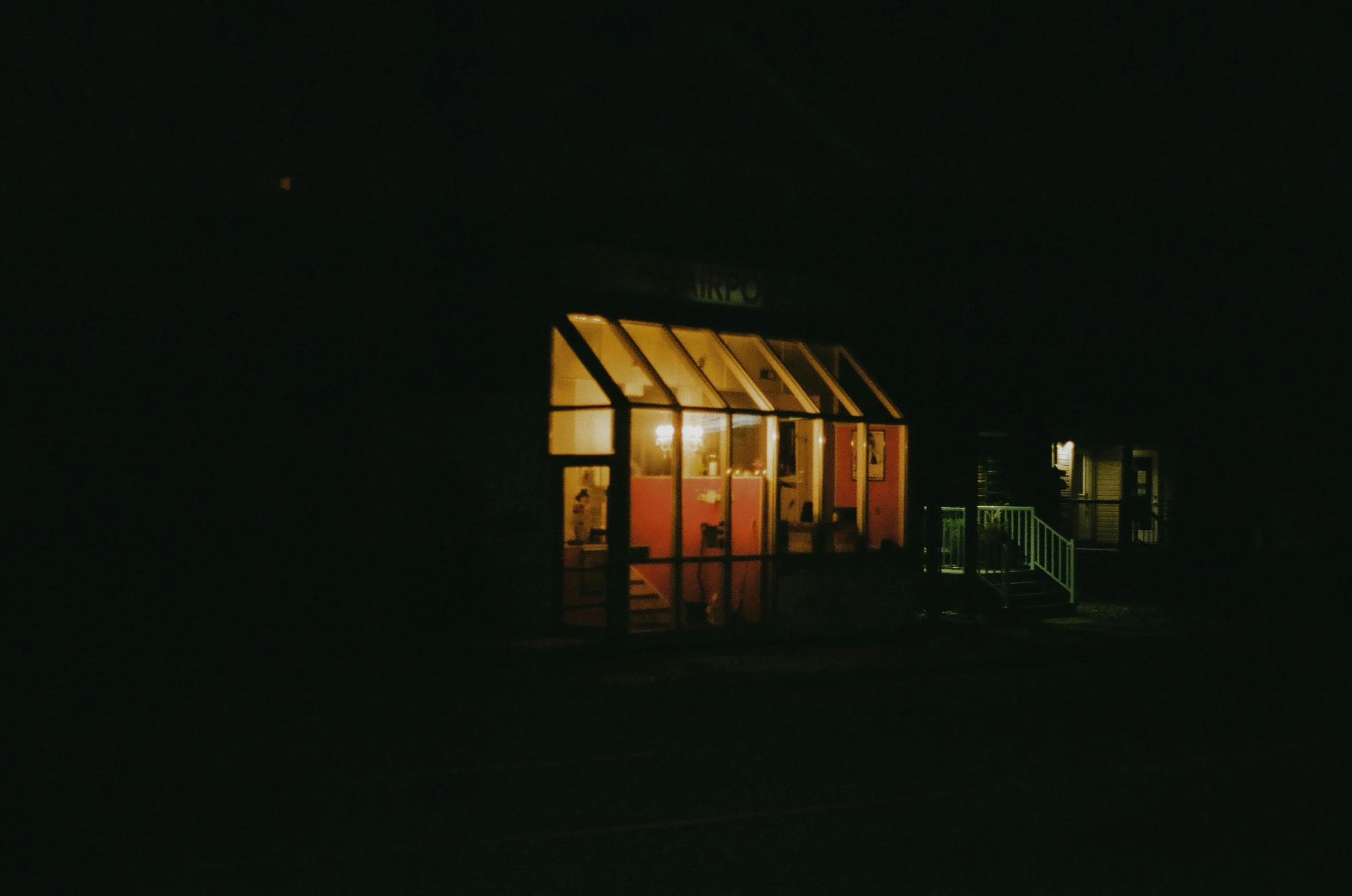 a small building lit up at night in the dark, by Elsa Bleda, diner, vintage color, rinko kawauchi