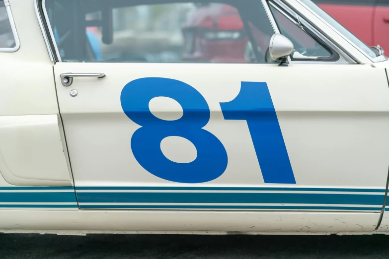 a close up of a car with the number 18 painted on it, by Tom Bonson, unsplash, photorealism, cream and blue color scheme, mustang, historical picture, 🚿🗝📝