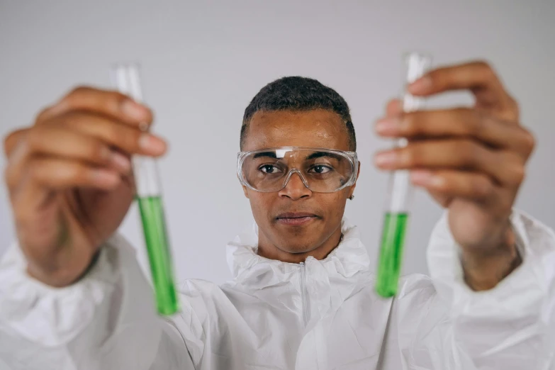 a man in a lab coat holding two test tubes, pexels contest winner, afro tech, green robes, gif, plating