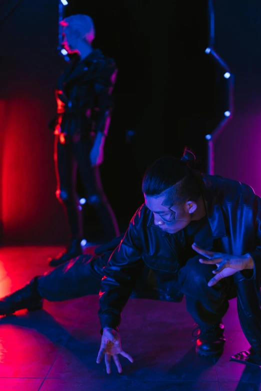 a group of people standing on top of a stage, unsplash, visual art, portrait of combat dancer, focus on two androids, kneeling at the shiny floor, purple scene lighting