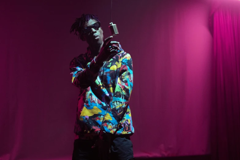 a man holding a cell phone up to his ear, an album cover, pexels, visual art, 2 1 savage, standing in a dimly lit room, brightly coloured, drips