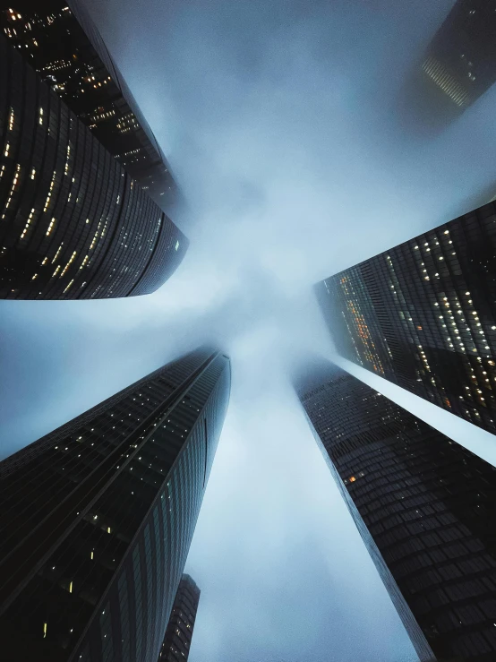 skyscrapers in a foggy city at night, an album cover, pexels contest winner, hypermodernism, low angle fisheye view, three towers, top down perspecrive, vertical architecture