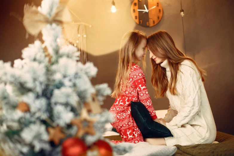 a couple of women sitting on top of a bed next to a christmas tree, by Julia Pishtar, shutterstock, fine art, ( redhead, with a kid, calmly conversing 8k, red brown and white color scheme