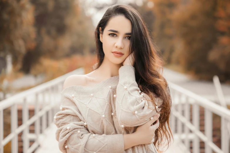 a woman posing for a picture on a bridge, a picture, trending on pexels, arabesque, brown sweater, pale-skinned persian girl, beautiful precise face and body, professional modeling