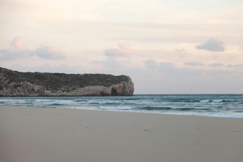 a man riding a surfboard on top of a sandy beach, les nabis, pink skies, island with cave, image from afar, australian beach