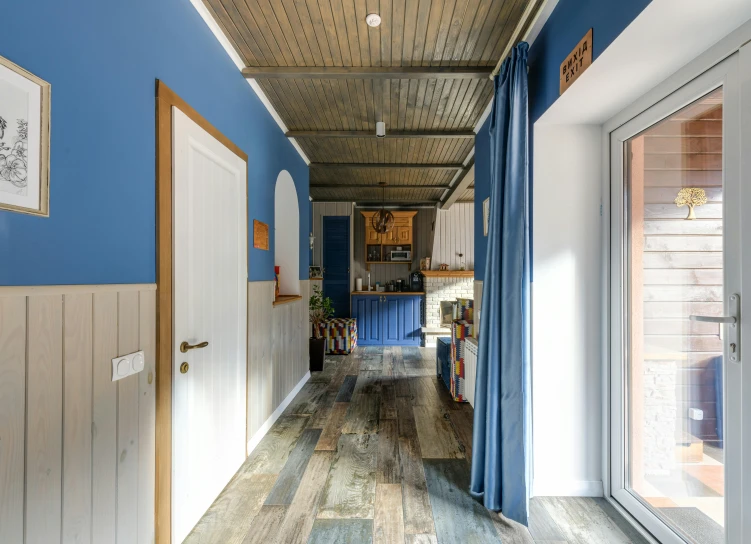 a hallway with blue walls and wood floors, by Jan Tengnagel, unsplash, ecovillage, arrendajo in avila pinewood, house kitchen on a sunny day, private academy entrance