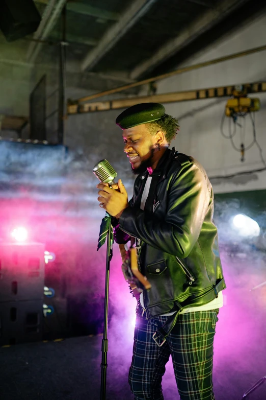 a man standing next to a microphone on a stage, an album cover, unsplash, visual art, stood in a factory, sussy baka, flashing lights, ( ( theatrical ) )